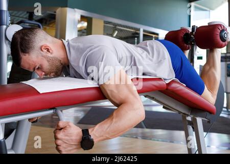 Young man doing leg exercise in gym Stock Photo