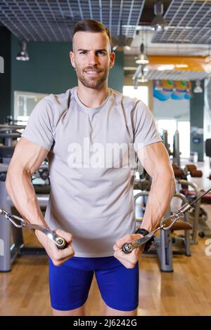 Smiling young man working out in gym Stock Photo