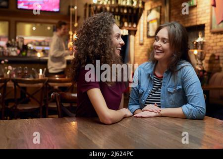 Two female friends talking in a pub Stock Photo
