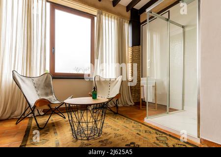 Chairs and table by shower in hotel Stock Photo