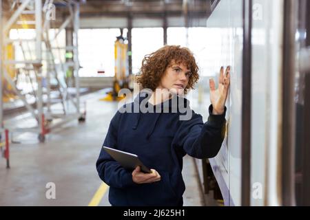 Engineer holding tablet PC analyzing monorail in factory Stock Photo