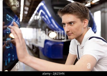 Trainee working on touch screen device in factory Stock Photo