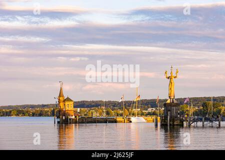 Germany, Baden-Wurttemberg, Konstanz, Harbor on shore of Lake Constance at dusk with lighthouse and statue of Imperia in background Stock Photo