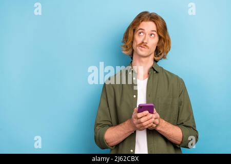Portrait of attractive funky minded guy using device app 5g creating new post copy space isolated over bright blue color background Stock Photo