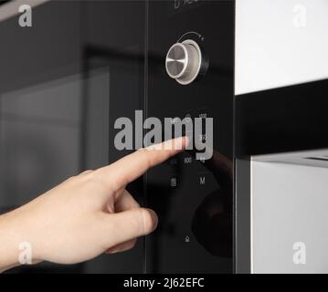 https://l450v.alamy.com/450v/2j62efc/a-mans-hand-presses-the-touch-panel-of-a-modern-microwave-oven-to-select-the-power-and-function-of-heating-food-2j62efc.jpg