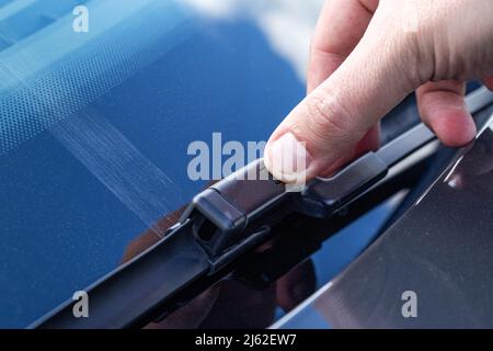 Replacing a car windshield wiper wiper with graphic coating wipers, close-up. Industry Stock Photo