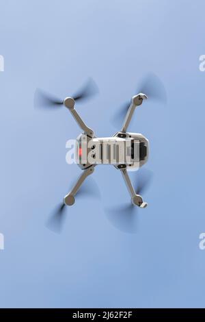 Bottom view of a drone flying with the light blue sky on the background Stock Photo