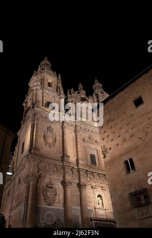 night view of the historic buildings, the Church of the 'Clerecia' and 'Casa de las conchas' illuminated in Salamanca, Spain Stock Photo