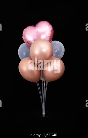 Set of balloons inflated with helium pink and white on a black background, isolate. Stock Photo
