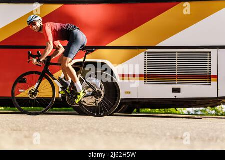 Young white man in helmet smiling while riding bicycle outdoors Stock Photo