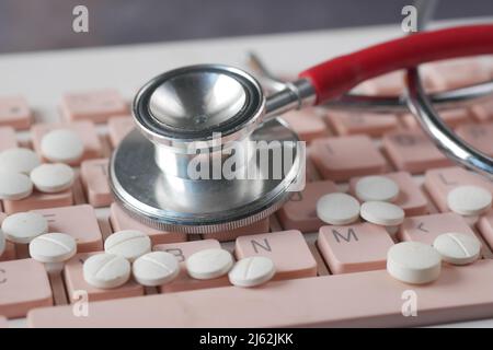Close up of pills and stethoscope on keyboard  Stock Photo