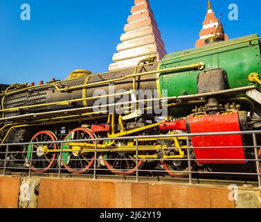 vintage steam rail engine with temple and blue sky background at day image is taken patna college patna bihar india on Apr 15 2022. Stock Photo