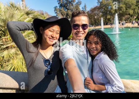 Group of young friends taking a selfie on vacation visiting a landmark. Stock Photo