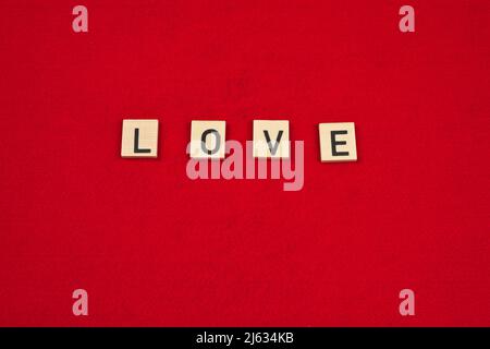 Word "Love" on a red felt background Stock Photo