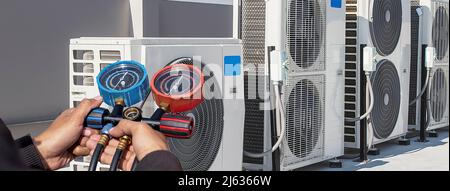 Technician checking the operation of the air conditioner. Stock Photo