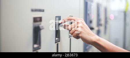 Engineers working to inspect and maintain electrical control cabinets. Stock Photo