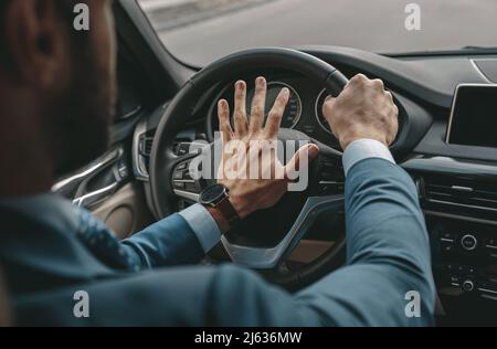 Unrecognized man in formal wear traveling by a car Stock Photo