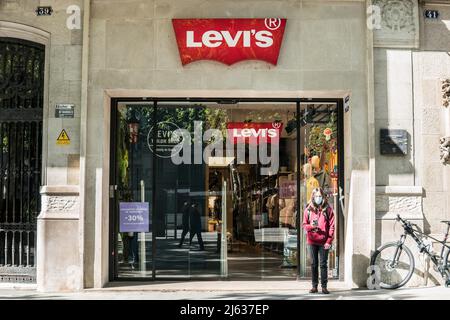 A woman stands outside the American clothing company brand Levi Strauss & Co. store in Barcelona. Stock Photo