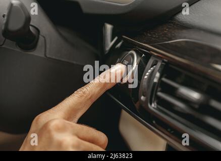Hand pushing on the dashboard of automobile Stock Photo