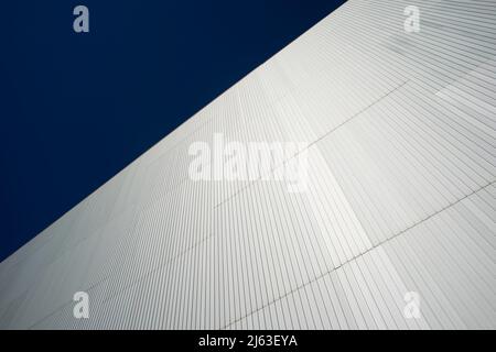 steel cladding on the side of a modern building with a blue sky. Stock Photo