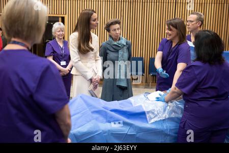 The Princess Royal, patron of the Royal College of Midwives (RCM), and The Duchess of Cambridge, patron of the Royal College of Obstetricians and Gynaecologists (RCOG), watch a demonstration of a mock emergency caesarian operation by Dr Katie Cornthwaite using a dummy, during a visit their headquarters in London, to hear about the ways in which the RCM and the RCOG are working together to improve maternal health care and meet representatives from Tommy's National Centre for Maternity Improvement. Picture date: Wednesday April 27, 2022. Stock Photo