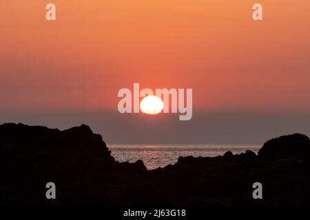 Sunset over the Irish Sea from Church Bay on Anglesey, North Wales Stock Photo