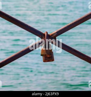 Two padlocks of lovers on the iron railing of the Tinto dock in Huelva Stock Photo