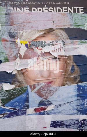 French Presidential Election 2022. Layers of torn campaign posters ripped to reveal the face of the populist right wing candidate Marine Le Pen. Paris. Stock Photo