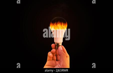 Burning Ideas Concept Background with Fire inside Bulb, Man Holding Bulb with Fire inside it. New ideas backdrop. Abstract Art design Stock Photo