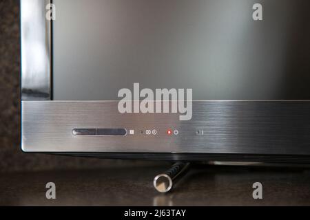 Close up of flat screen television standby button left on, indoors at UK residential home. Stock Photo