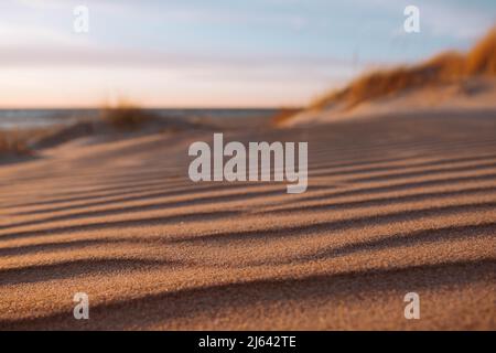Dune waves and sand pattern. Wave, sand dunes, dry desert, brown or yellow colored. The sand changes shape due to the wind to form sand ripples and ja Stock Photo