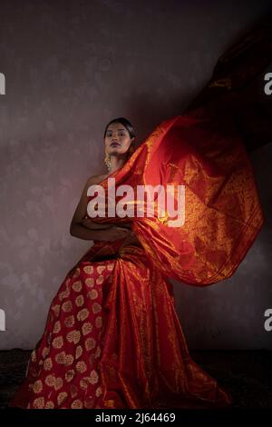 beautiful indian girl wearing a traditional indian saree orange color shooting in a studio Stock Photo