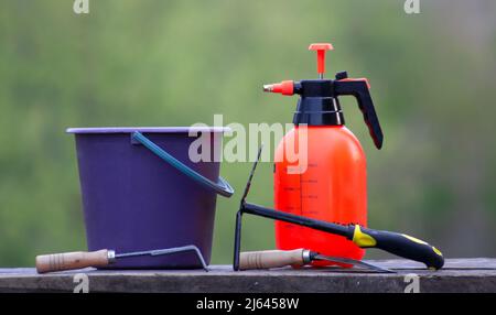 Garden tools on wooden boards. Bucket sprayer and garden tools. Stock Photo