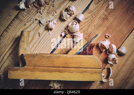 Old wooden carpenters tool plane on a wooden background Stock Photo