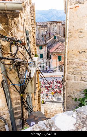 KOTOR, MONTENEGRO - September 16, 2019: Tangled wires and cables between old houses in Kotor city in Montenegro Stock Photo