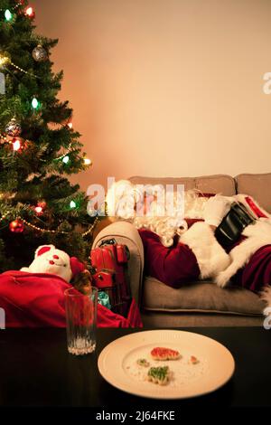 Santa Claus taking a nap while delivering toys on Christmas Eve. Stock Photo
