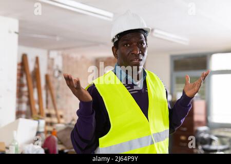 Worried puzzled architect standing in building during renovation Stock Photo