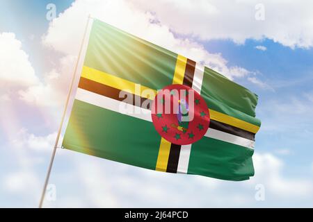 Sunny blue sky and a flagpole with the flag of dominica Stock Photo