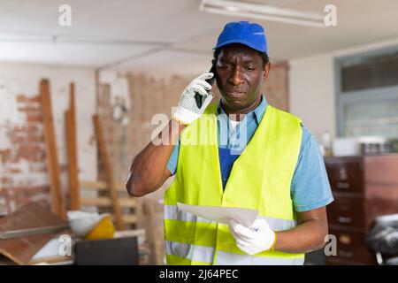Man construction worker having telephone conversation about documentation Stock Photo