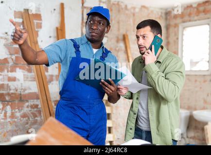Two men talking on indoor construction site Stock Photo