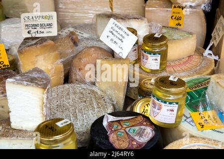 A variety of cheeses and honey on display at the Saturday morning market in Alba in the Piedmont region of Italy Stock Photo