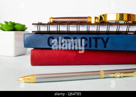 left hand writing inscription capacity with red color marker, concept, stock image Stock Photo