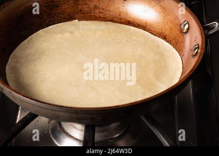 Cooking Tandoori Roti in frying pan, a typical flatbread and popular in West, Central and South Asia. Stock Photo