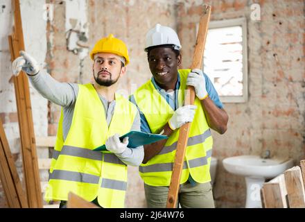 Two builders talking on indoor construction site Stock Photo