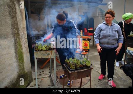 April 24, 2022, Pagani, Campania/Salerno, Italy: During the days of the Feast of Our Lady of Mount Carmel, called ''of the hens'', the traditional food of this religious festival is prepared for the historic center. Women cook artichokes on small kilns, while men prepare in large pots the sauce to be used for the traditional homemade pasta called ''tagliolini' (Credit Image: © Pasquale Gargano/Pacific Press via ZUMA Press Wire) Stock Photo