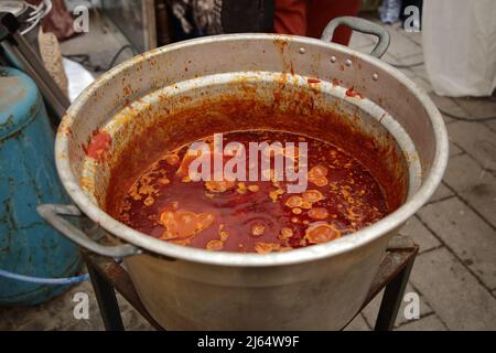 April 24, 2022, Pagani, Campania/Salerno, Italy: During the days of the Feast of Our Lady of Mount Carmel, called ''of the hens'', the traditional food of this religious festival is prepared for the historic center. Women cook artichokes on small kilns, while men prepare in large pots the sauce to be used for the traditional homemade pasta called ''tagliolini' (Credit Image: © Pasquale Gargano/Pacific Press via ZUMA Press Wire) Stock Photo