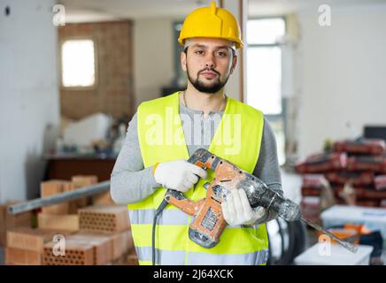 Portrait of professional builder with an industrial puncher in hands Stock Photo