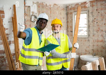 Two builders talking on indoor construction site Stock Photo