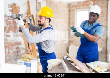 Man builder using electric hammer in construction site Stock Photo