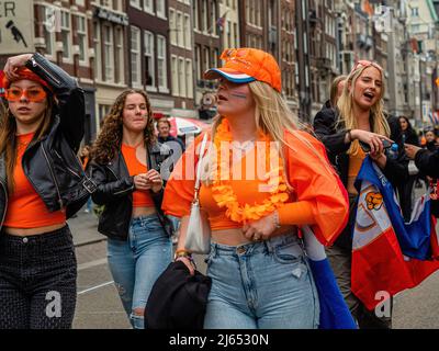 A group of women wearing orange clothes seen walking on the